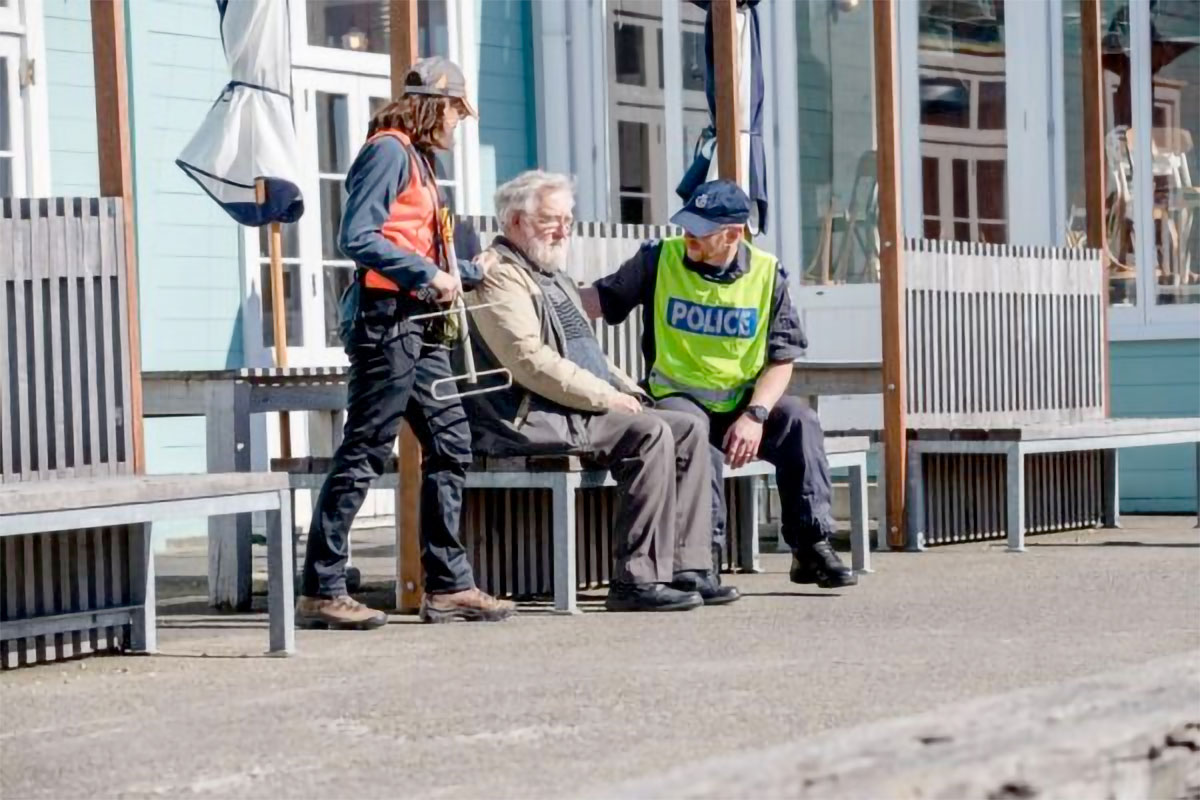 Police and volunteers with older man